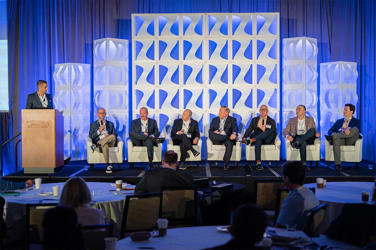 Investor panel on stage at a summit